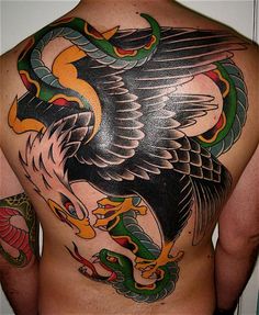 an eagle and snake tattoo on the back of a man's body is shown