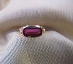 The color of this synthetic Spinel is a deep rose-pink, and the setting is delicate, with a small, subtle decoration on the sides of the shank. Synthetic Spinels were used frequently in Victorian and Edwardian jewelry. 10k gold. Size 5. Classic Pink Gold Rings For Formal Occasions, Formal Pink Gold Ruby Ring In 14k Gold, Formal 14k Pink Gold Ruby Ring, Classic Pink Ruby Ring For Formal Occasions, Pink Solitaire Jewelry For Formal Occasions, Classic Pink Ring Stamped 14k, Formal Pink Gold Solitaire Jewelry, Pink Gold Ruby Ring For Formal Occasions, Formal Pink Gold Ruby Ring In Fine Jewelry Style