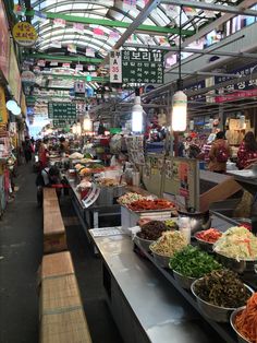 an indoor market filled with lots of food and veggies on the counter top