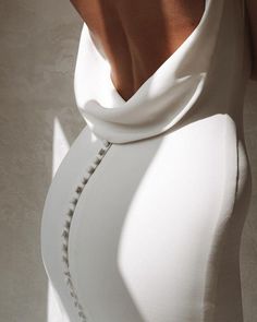 the back of a woman's white dress with buttons on it