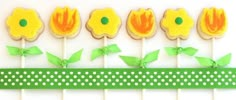 some yellow flowers and green leaves are on top of the cupcakes that have been cut out