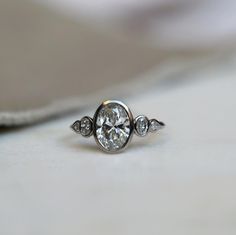 a diamond ring sitting on top of a white surface