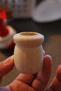 a person holding a small wooden cup in their hand