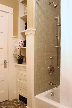 a bath tub sitting next to a white door in a bathroom with tile flooring