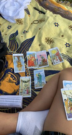 a woman laying on top of a blanket next to tarot cards