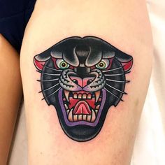 a black cat tattoo on the thigh