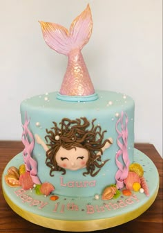 a birthday cake with a little mermaid on top