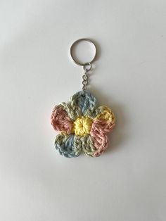 a crocheted flower keychain is shown on a white surface with a silver ring