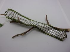 a white and green piece of jewelry sitting on top of a table