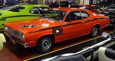 an orange car parked in a garage next to other cars