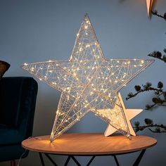 a lighted star sitting on top of a wooden table