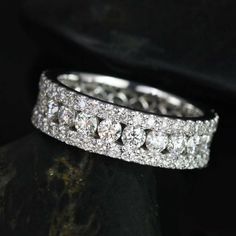 a diamond ring sitting on top of a black stone slab with diamonds in the middle