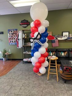 a balloon column in the shape of an airplane with red, white and blue balloons