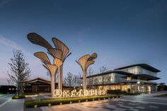 the entrance to an office building with large sculptures in front of it at night time