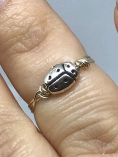 This dainty ladybug ring is perfect for anyone who wants to create a minimalistic look. Each one is made to order and wrapped in silver wire. Rings can be made in any US ring size from 3 to 15, including half and quarter sizes. This tiny ladybug would also make a great gift! All rings are packaged in jewelry boxes and shipped via USPS First Class. Shipping is available World Wide and can be upgraded to Priority or Priority Express. Need a different size or want a different color wire? Please contact me with requests and questions. Thank you for visiting my shop today! Follow my shop on social media: Instagram: @savetimeinabauble Twitter: @svetimeinabaubl Facebook: www.facebook.com/savetimeinabauble Second Shop: www.etsy.com/shop/needlefeltmenagerie Cute Adjustable Hypoallergenic Rings, Dainty Adjustable Stackable Metal Rings, Cute Adjustable Ring For Everyday, Cute Adjustable Everyday Rings, Cute Adjustable Nickel-free Rings, Adjustable Nickel-free Cute Rings, Adjustable Cute Nickel-free Rings, Ladybug Ring, Ladybug Jewelry