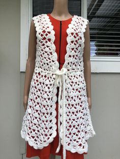 This vintage 70s wool crochet waistcoat vest in antique white wool blend would make a useful addition to your wardrobe in the forthcoming cooler months. The sleeveless tunic-style waistcoat with its waist draw string is perfect for layering and offers a regular fit in size S for women. The vest features intricate crochet detailing, adding a touch of charm and elegance to any outfit. Crafted from high-quality wool blend, this waistcoat vest is both comfortable and durable, making it perfect for a Fall Sleeveless Crochet Top With Crochet Trim, Sleeveless Crochet Top With Crochet Trim For Fall, Sleeveless Crochet Lace Top For Fall, White V-neck Vest Outerwear, White Sleeveless Crochet Top For Fall, Vintage White V-neck Outerwear, White Crochet Vest For Spring, White Fitted Bohemian Vest, Vintage Crochet Sleeveless Vest