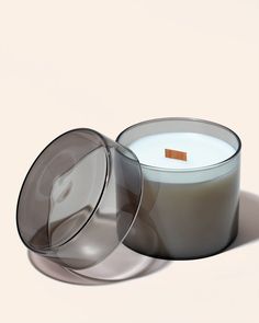 an image of a candle that is in the shape of a glass container with a wooden stick sticking out of it