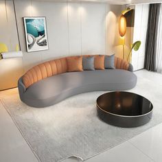 a large curved couch sitting on top of a white floor next to a round table