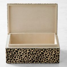 an open box with a leopard print design on the lid and bottom, sitting on a white surface