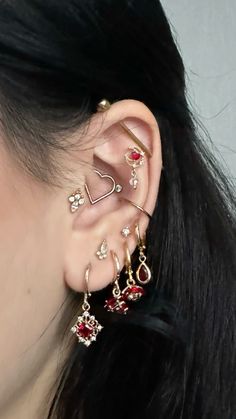 a close up of a person with ear piercings on their ears and wearing jewelry