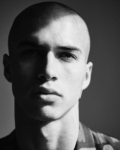 black and white photograph of a young man with short hair wearing a striped t - shirt