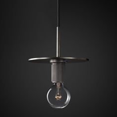 a light bulb hanging from a ceiling fixture in a dark room with black walls and flooring