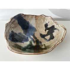 a ceramic bowl with blue and black designs on the bottom, sitting on a white surface