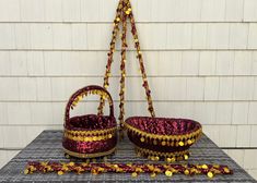 two baskets are sitting on a table next to a string of beaded thread and beads