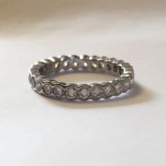 a white gold diamond wedding ring on a plain surface with the center stone set in two rows