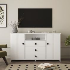 a white entertainment center with a book on the floor