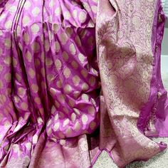 This stunning pink 100% Mulberry Katan silk saree is handwoven in Banaras, known for its intricate designs and high-quality craftsmanship. The saree features a beautiful shade of dual - pinkish purple with golden zari jaal work, creating a mesmerizing effect. The saree is perfect for any special occasion, such as a wedding, festival, or formal event. Comes finished with hand fall and Pico. And a blouse piece with zari border. Silk Mark Certified Note: Colors that show up on your screen may vary slightly from the actual product due to variations in settings. Also, the actual product may appear to be different hues depending on the ambience lighting.Note: There may be very slight inconsistencies such as in the weave/motiff work or color , there being characteristics are not considered defect Unstitched Purple Traditional Blouse Piece, Unstitched Traditional Purple Blouse Piece, Elegant Purple Pre-draped Saree For Celebration, Traditional Purple Tussar Silk Blouse Piece, Festive Purple Raw Silk Traditional Wear, Purple Blouse Piece With Dupatta For Celebration, Celebration Purple Blouse Piece With Dupatta, Eid Purple Raw Silk Blouse Piece, Pink Tussar Silk Blouse Piece For Eid