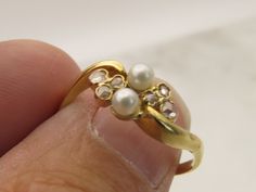 ESTATE ANTIQUE 14K GOLD PEARL AND ROSE CUT DIAMOND RING SIZE 7. GREAT SHAPE.  UNMARKED AND ACID TESTS FOR 14K. 1.8 GRAMS. 7MM WIDE. 6 SMALL ROSE CUT DIAMONDS AND TWO 2.8MM PEARLS. WILL COME IN NICE RING BOX. PLEASE BE ADVISED SOME PHOTOS ARE CLOSEUPS TO SHOW DETAIL, PLEASE READ FULL DESCRIPTION FOR BETTER UNDERSTANDING OF SIZE.  This item is preloved and Antique/Vintage. This means it may have signs of wear and use and is offered as is.  You will receive the exact item shown in the photos. There Formal Yellow Gold Pearl Ring With Rose Cut Diamonds, Formal 14k Gold Pearl Ring With Rose Cut Diamonds, Cluster Yellow Gold Pearl Ring For Anniversary, Gold Cluster Pearl Ring Gift, Gold Cluster Pearl Ring For Formal Occasions, Rose Gold Pearl Ring, Diamond Pearl Ring, Gold Wire Ring, Rose Cut Diamond Ring