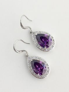 I've created these gorgeous purple amethyst cubic zirconia bridal tear drop dangle earrings in rhodium plated brass setting. Earrings feature a large teardrop with pear cut purple amethyst cubic zirconia center surrounded by tiny round zirconia crystals. Teardrop dangles from a cubic zirconia detailed ear wire. Total length of the earring is 3.8 cms. For matching necklace click: https://www.etsy.com/listing/479272957/amethyst-cubic-zirconia-teardrop-bridal?ref=shop_home_active_19 For matching br Lavender Drop Earrings For Formal Occasions, Lavender Dangle Earrings For Formal Occasion, Purple Dangle Bridal Earrings, Purple Cubic Zirconia Earrings For Pierced Ears, Purple Cubic Zirconia Earrings For Party, Purple Cubic Zirconia Earrings, Purple Cubic Zirconia Party Earrings, Lavender Crystal Earrings For Wedding, Elegant Purple Jewelry With Ear Wire