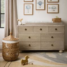 a baby's room with a crib, dresser and pictures on the wall