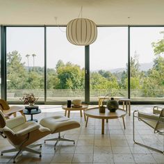 a living room filled with lots of furniture and large glass doors leading to the outside