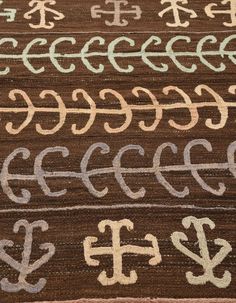 the letters and numbers are written in cursive writing on a brown rug with white trim