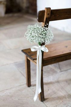 a bouquet of baby's breath sits on a bench