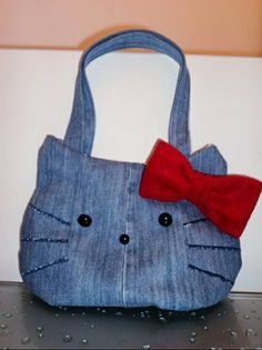 a cat purse with a red bow on it