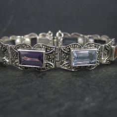 This gorgeous vintage bracelet is sterling silver with 6x10mm emerald cut gemstones and marcasites. It features 3 amethysts, 3 blue topaz and 2 citrines. Measurements: 1/2 of an inch wide - 6 1/2 wearable inches Weight: 24.9 grams Marks: 925, CL Condition: Excellent Silver Gemstones With Jewels In Fine Jewelry Style, Elegant Silver Gemstones With Jewels, Antique Silver Gemstone Bracelet, Elegant Multi-stone Rectangular Jewelry, Vintage Silver Multi-stone Gemstones, Vintage Multi-stone Silver Gemstones, Classic Silver Multi-stone Gemstones, Vintage Sterling Silver Bracelet With Gemstone, Vintage Silver Gemstone Bracelets