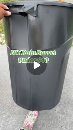 a person is standing next to a trash can with the words diy rain barrel under $ 40