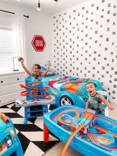 two young boys playing in their cars themed bedroom