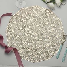 a place setting with flowers, silverware and ribbon on the table next to it