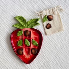 a strawberry shaped chocolate mold sitting on top of a white table next to a bag