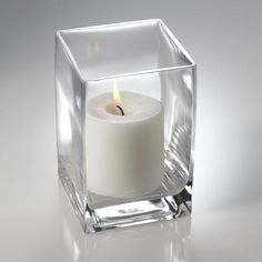 a white candle in a clear glass holder