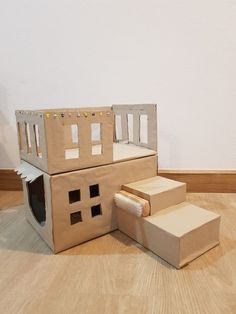 cardboard boxes are stacked on top of each other in the shape of a house with windows and doors