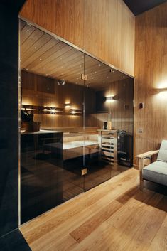 a living room filled with furniture and wooden walls next to a wall covered in mirrors