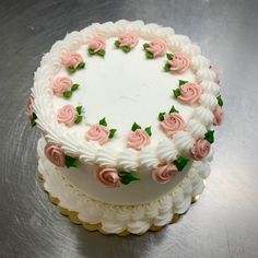 a cake with white frosting and pink flowers on it