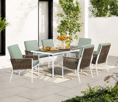 an outdoor dining table and chairs set up on a patio