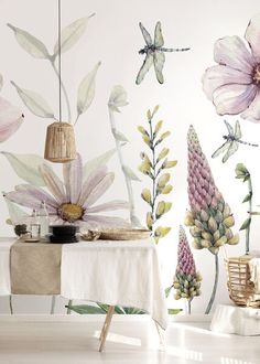 a dining room with flowers and dragonflies on the wall, along with a table