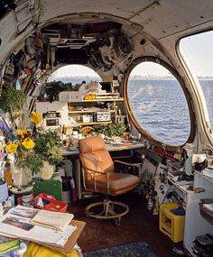 the inside of an airplane with lots of clutter and flowers on it's desk